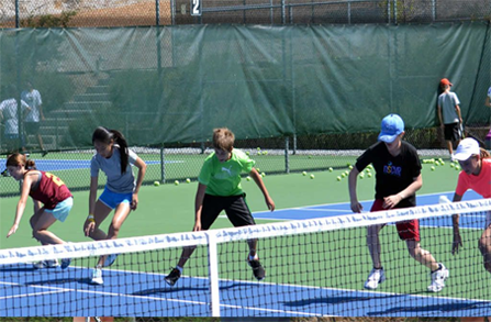 Thumbnail an ISC monitor and students practising their tennis forehands in Spain